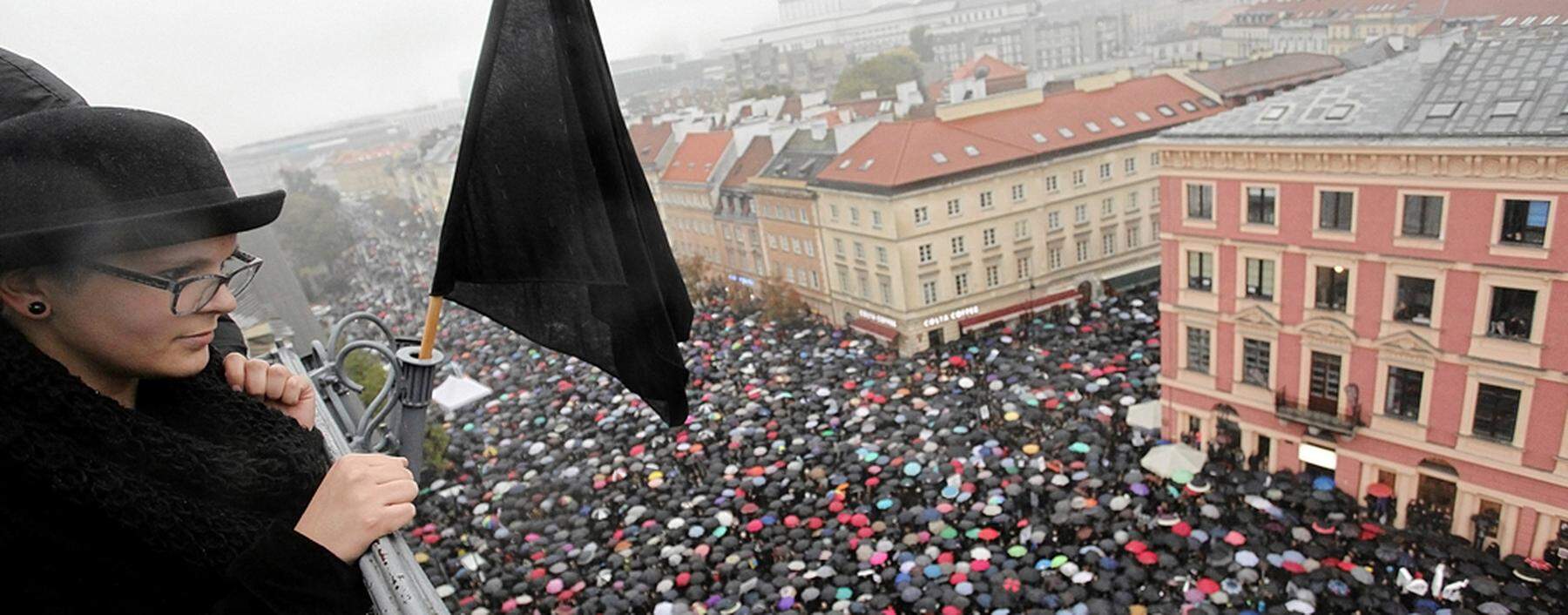 A woman observes thousands of people during an abortion rights campaigners´ demonstration to protest against plans for a total ban on abortion in front of the Royal Castle in Warsaw