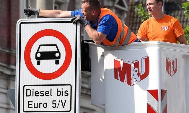 FILE PHOTO: Traffic signs which ban diesel cars are installed by workers at the Max-Brauer Allee in downtown Hamburg