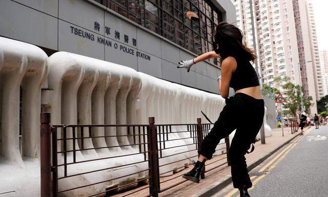 Die Demokratiebewegung in Hongkong scheint sich allmählich zu radikalisieren. Eine vermummte Aktivistin wirft einen Stein gegen eine Polizeistation im Wohnviertel Tseung Kwan O. 