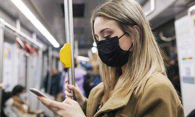 Passenger with protective face mask using smart phone in train model released, JRVF02667