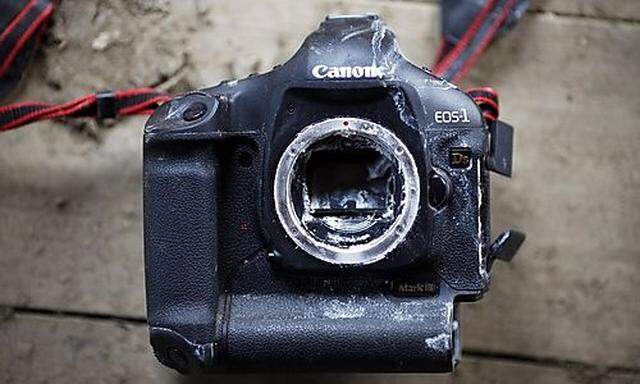 A destroyed professional Canon SLR photo camera is photographed in a house damaged by an earthquake a