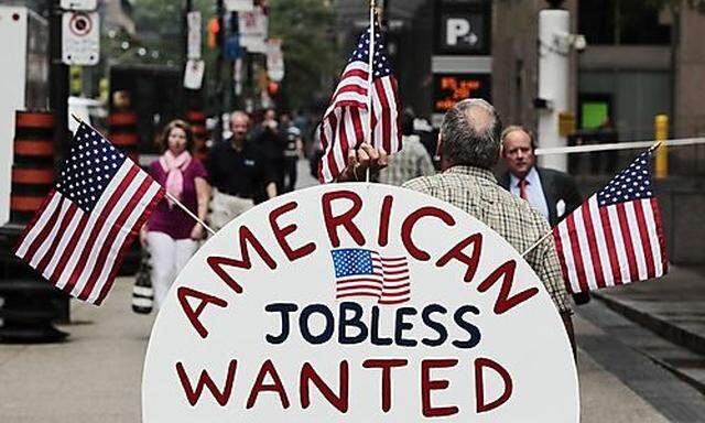 A man holds a sign reading American Jobless Wanted on the street ahead of the G20 summit in Toronto