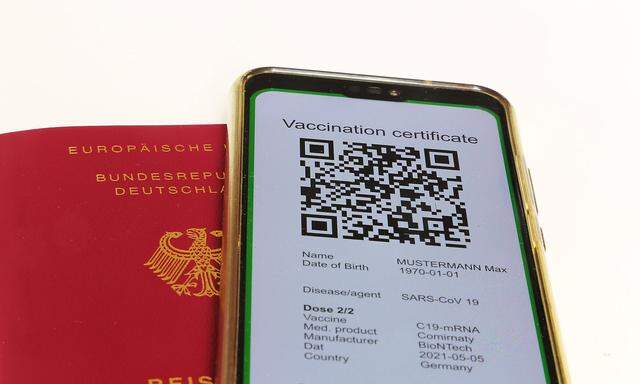 Symbolbild: Reisepass und ein digitaler Gruener Pass als Nachweis einer Impfung *** Symbolic passport and a digital gree