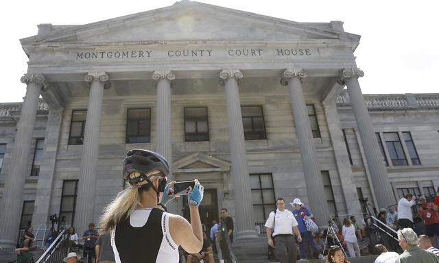 A cyclist takes a picture of the Montgomery County Courthouse on the fourth day of jury deliberation in Bill Cosby´s sexual assault trial in Norristown