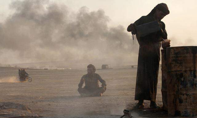 File picture shows a man working at a makeshift oil refinery site in al-Mansoura village in Raqqa