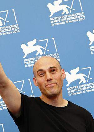 Swedish filmmaker Roy Andersson gestures as he arrives on the red carpet for an award ceremony at the 71st Venice Film Festival