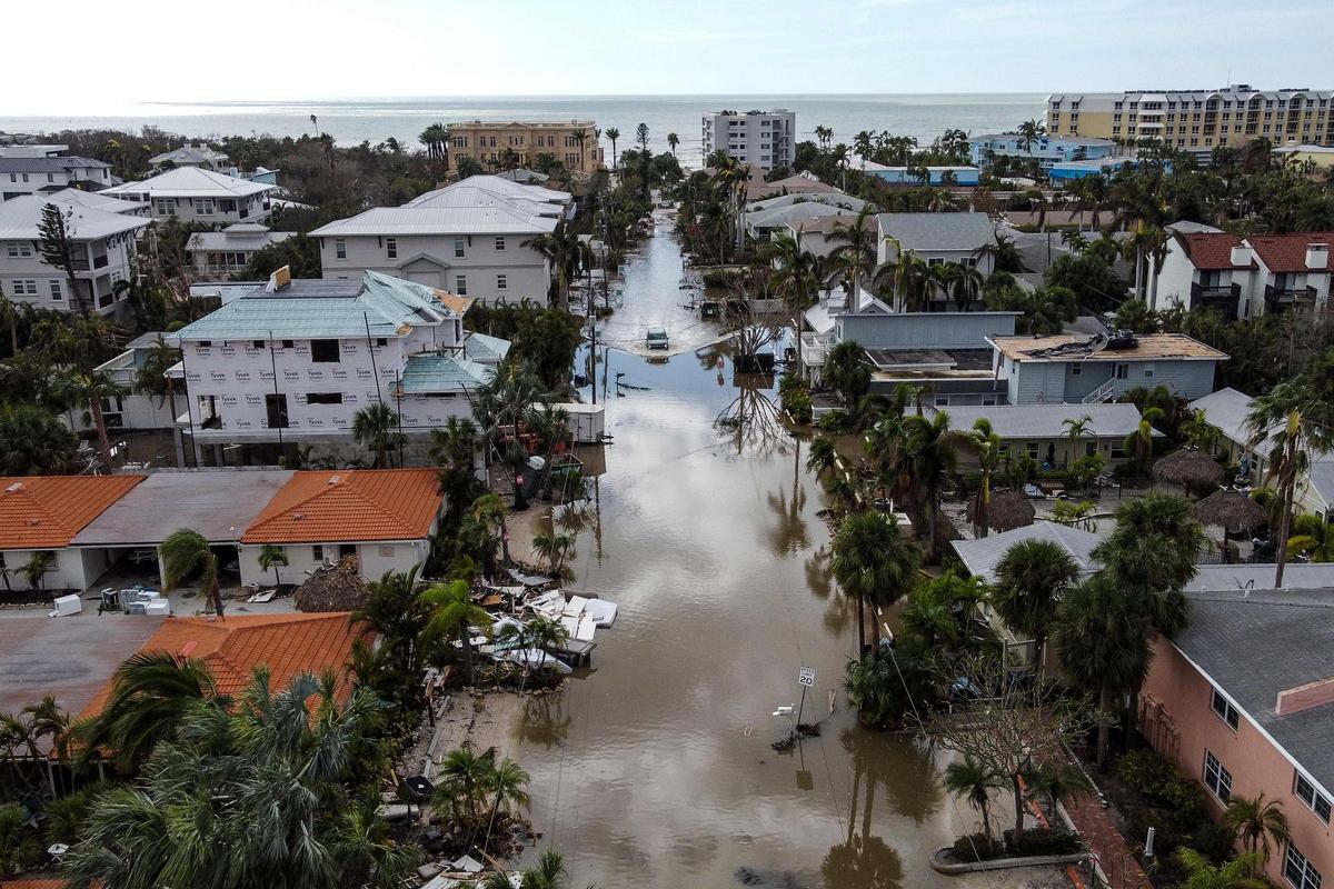 A car drives through a flooded street in Siesta Key, Florida 