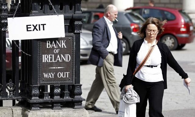 People walk past a bank in Dublin