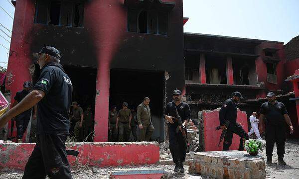Polizeibeamte inspizieren am 17. August eine niedergebrannte Kirche der Heilsarmee in Jaranwala am Stadtrand von Faisalabad.