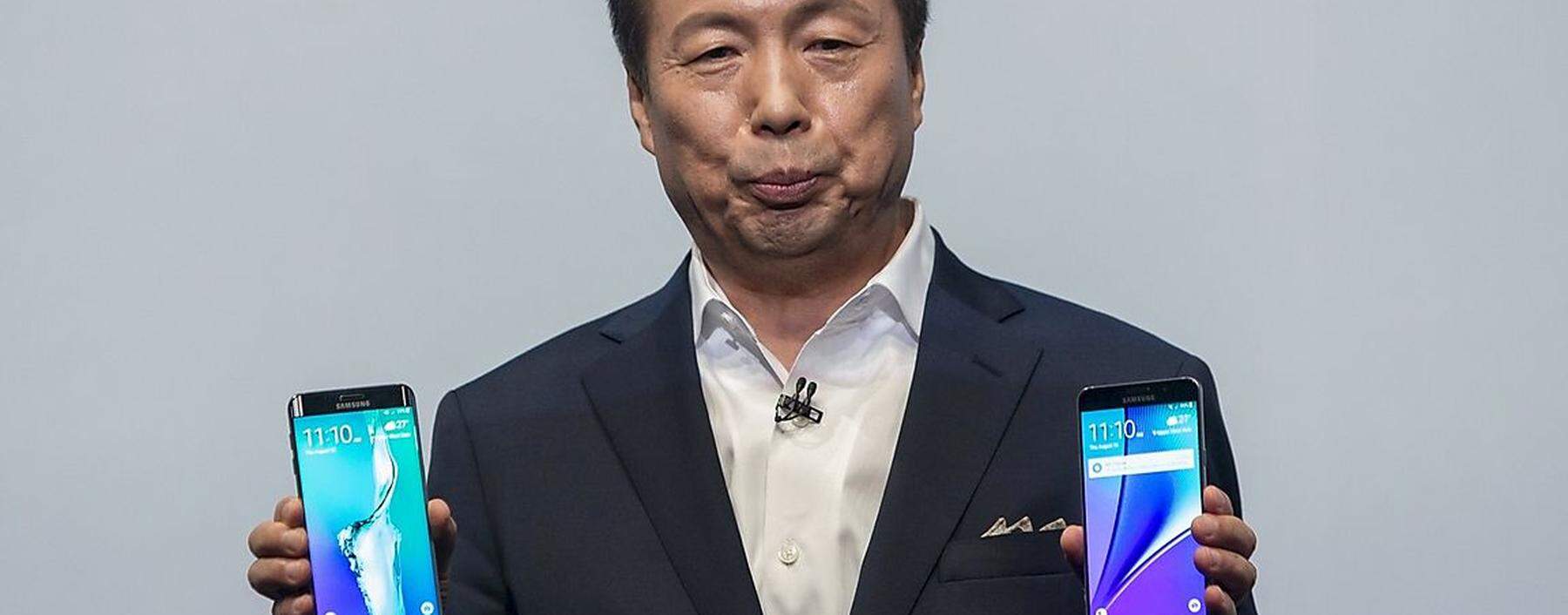 President and CEO of Samsung Electronics J.K. Shin holds a Samsung Galaxy S6 Edge+ and a Samsung Galaxy Note 5 at the products' launch event in New York