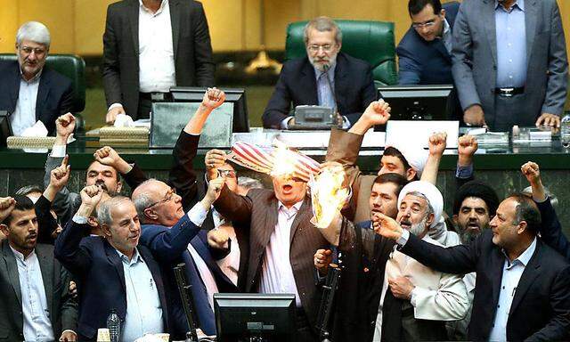 Im iranischen Parlament zündeten Abgeordnete als Reaktion auf Trumps Entscheidung eine US-Flagge an.