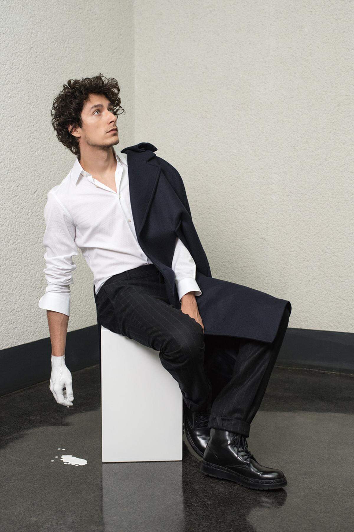 Noah Saavedra trägt ein Hemd von Brunello Cucinelli, ein Cape von Prada, eine Hose von Hermès und Schnürschuhe von Jil Sander.
