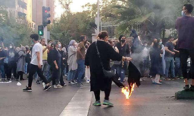 Aufstand gegen das theokratische Regime. Eine Frau in Teheran verbrennt ihr Kopftuch. 