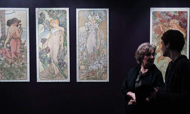 MOSCOW RUSSIA FEBRUARY 20 2019 Visitors walk past posters by Alphonse Mucha on display at an e