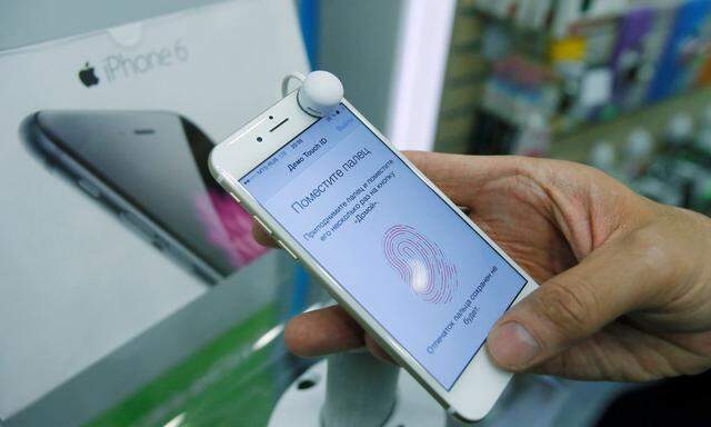 Man holds iPhone 6 in mobile phone shop in Moscow