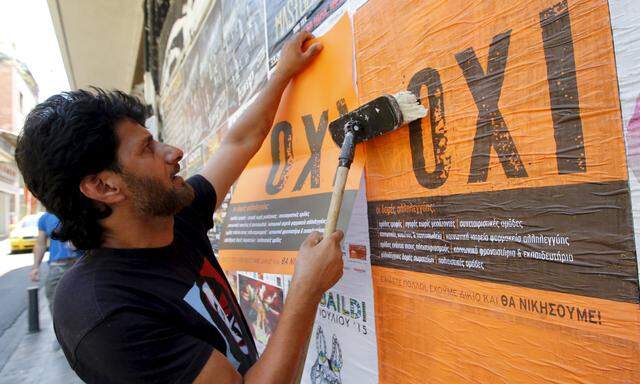 A man puts up posters with the word ´No´ in Greek in Athens