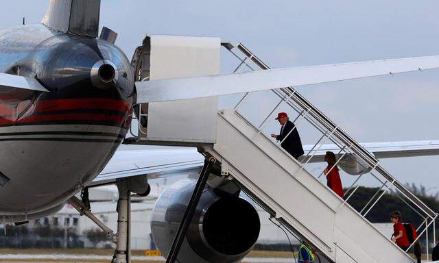 U.S. President-elect Donald Trump boards his aircraft with his wife Melania and son Barron in West Palm Beach