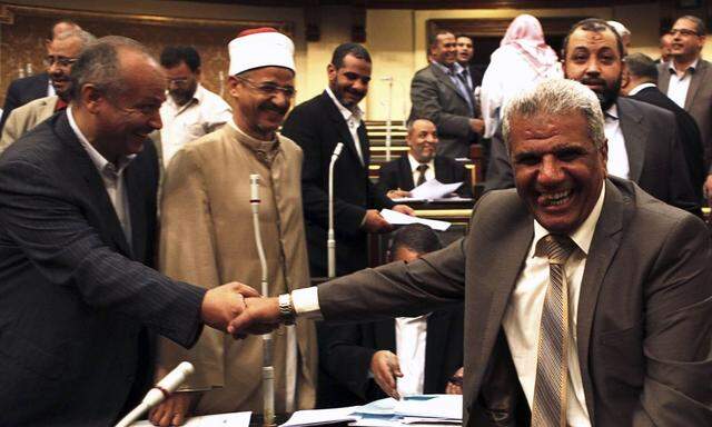 Islamist and Brotherhood members of the Shura Council, smile after the approval of the new judicial law during its meeting in Cairo