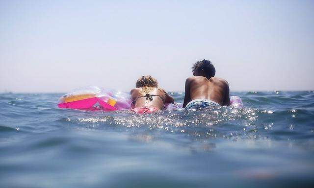 A couple swims in the sea during a hot summer's day at Ostia beach, south of Rome