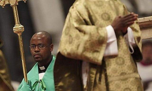 A priest holds Pope Benedict XVIs pastoral staff during a mass for the closing of African Synod in Ss pastoral staff during a mass for the closing of African Synod in S