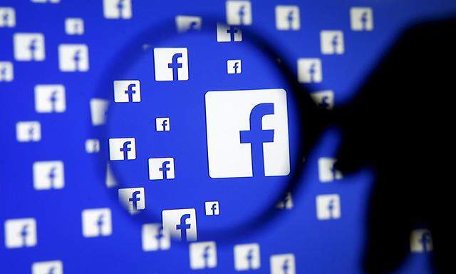 A man poses with a magnifier in front of a Facebook logo on display in this illustration taken in Sarajevo