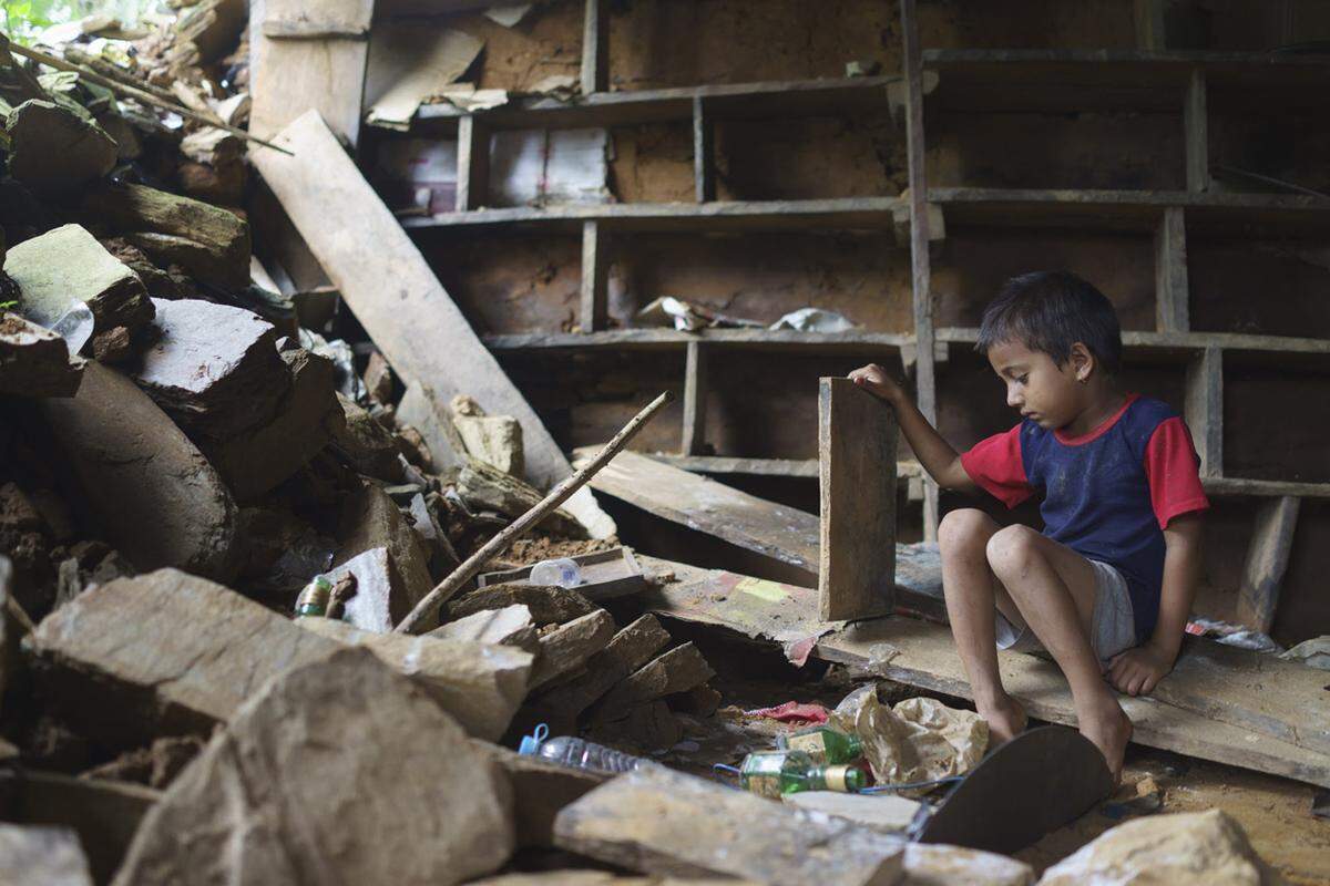Der sechs Jahre alte Durkesh Koirala sitzt zwischen den Trümmern seines ursprünglichen Elternhauses. Er versucht Gegenstände zu retten, mit denen er mit seinen Freunden spielen kann.