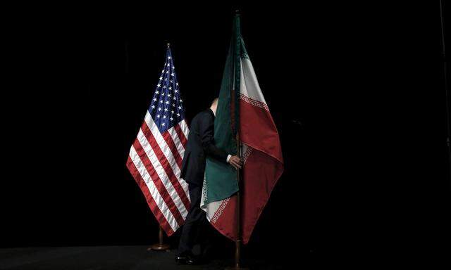 FILE PHOTO: A staff member removes the Iranian flag from the stage during the Iran nuclear talks at the Vienna International Center in Vienna