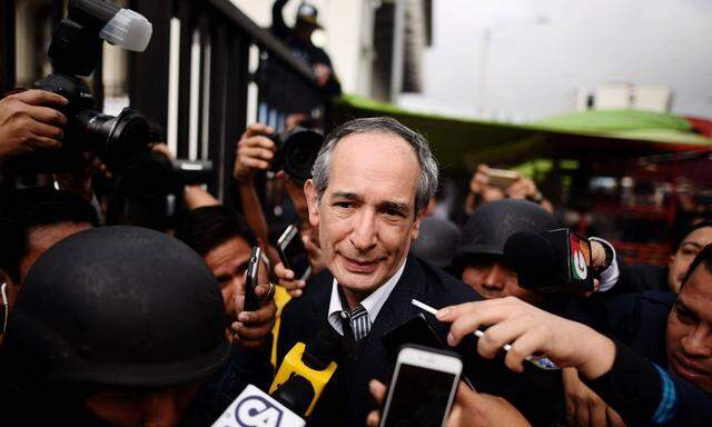 Guatemalan former President Alvaro Colom C delivers remarks to press as he is escorted after being
