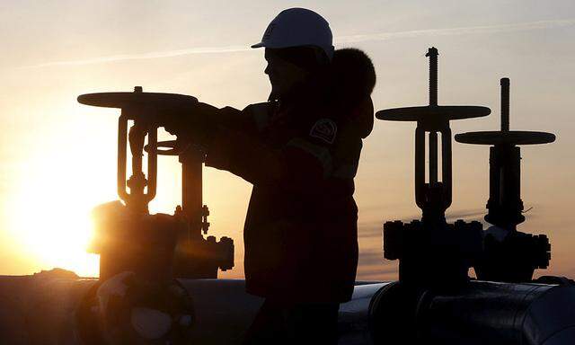 Worker checks valve of oil pipe at Lukoil company owned Imilorskoye oil field outside West Siberian city of Kogalym