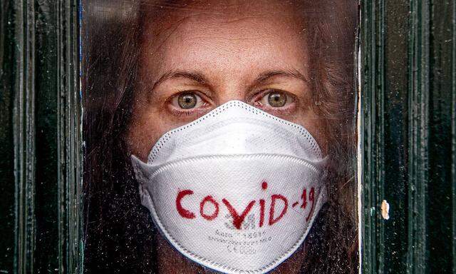March 17, 2020, The Hague, Netherlands: A covid-19 coronavirus patient poses for photo looking out from her front door