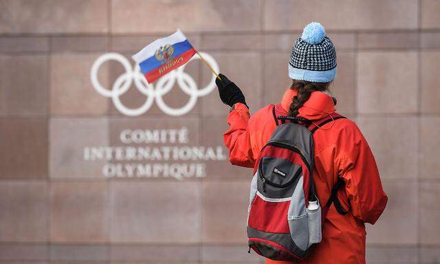 Eine Frau hält eine russische Fahne vor dem IOC-Gebäude