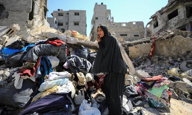 Frau inspiziert Schäden im Shejaiya-Viertel. 