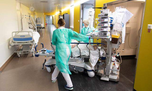 Medical workers push a bed with a patient in the emergency room unit at the CHUV in Lausanne