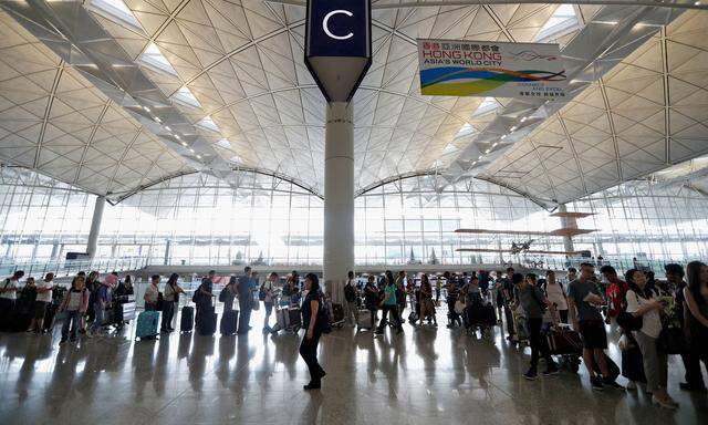 Passengers queue as the airport reopened a day after flights were halted due to a protest, at Hong Kong International Airport, China