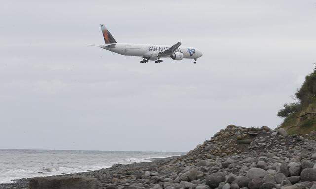 An airplane flies over the Jamaique beach in Saint-Denis on the French Indian Ocean island of La Reunion