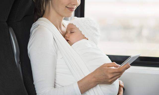 Mother with baby girl traveling by train looking on cell phone model released Symbolfoto PUBLICATION