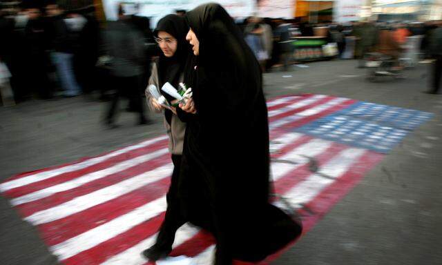 FILE PHOTO: Iranian women walk on a U.S. flag during a demonstration to mark the 27th anniversary of Iran´s Islamic Revolution in Tehran