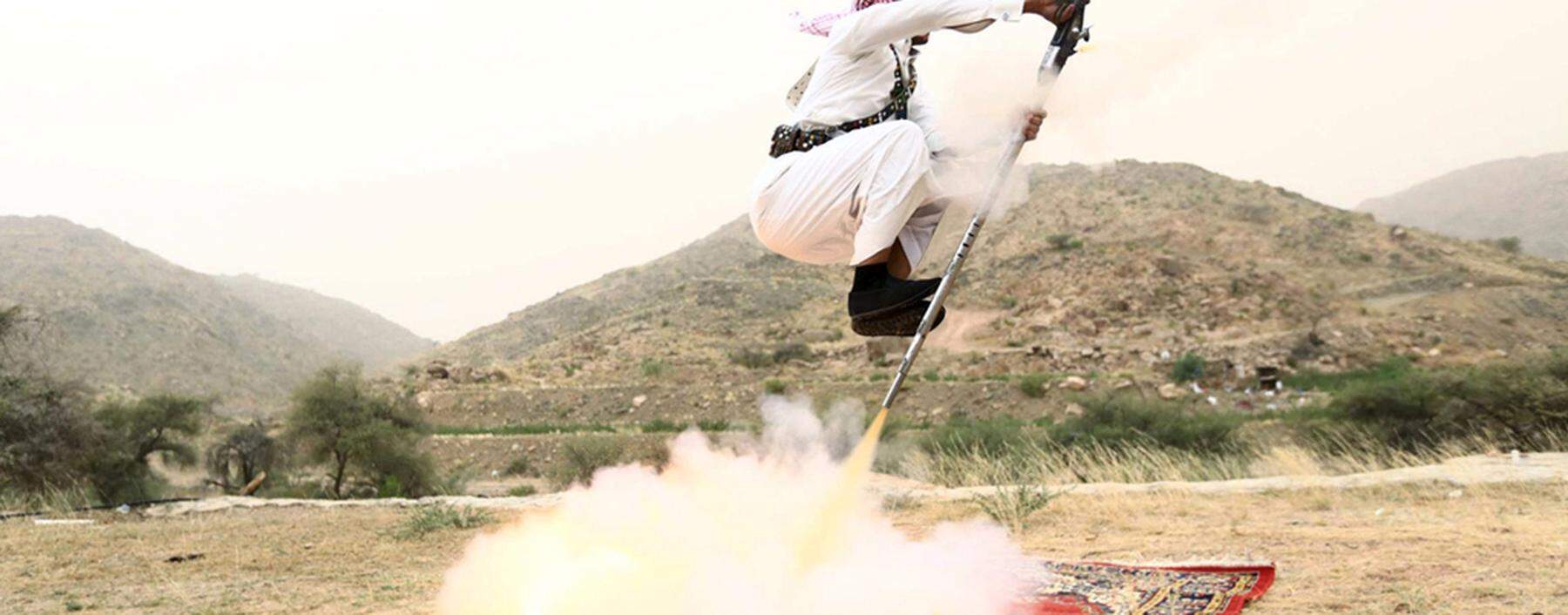 Man fires a weapon as he dances during a traditional excursion near the western Saudi city of Taif