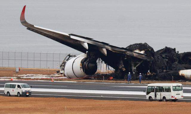 Ermittler untersuchen die Wrackteile der beiden kollidierten Flugzeuge am Flughafen Haneda.