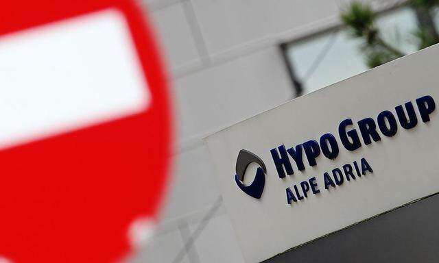 The logo of Hypo Alpe Adria is seen near a traffic sign at the bank's headquarters in Klagenfurt