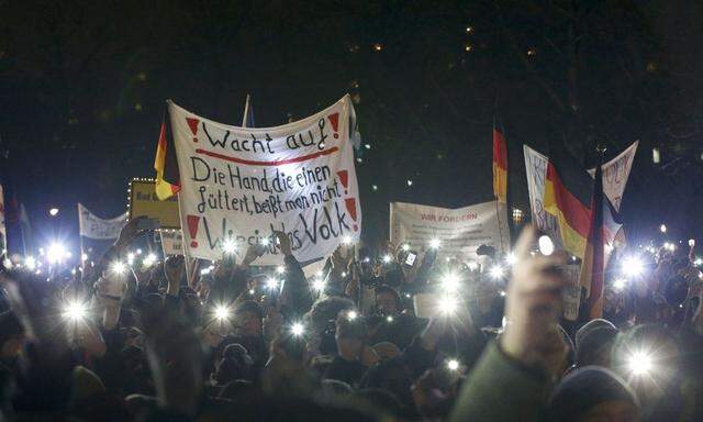 Participants use lights on their portable phones as they take part in a demonstration called by anti-immigration group PEGIDA, a German abbreviation for 'Patriotic Europeans against the Islamization of the West', in Dresden
