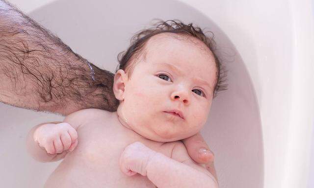 Parent bathing baby cropped PUBLICATIONxINxGERxSUIxAUTxONLY Copyright Anne SophiexBost B64850327