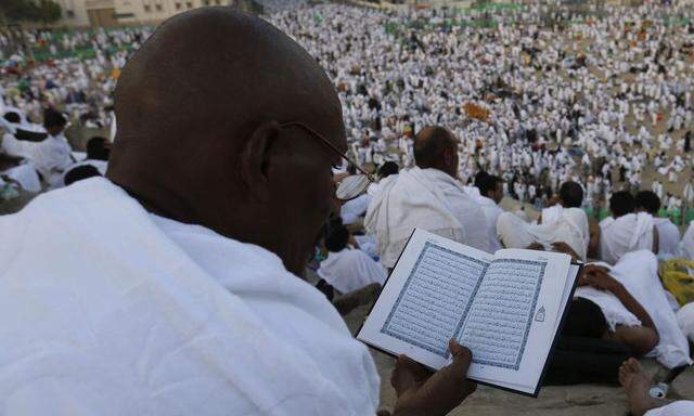 Muslim pilgrim reads the Koran on Mount Mercy on the plains of Arafat during the annual haj pilgrimage, outside the holy city of Mecca