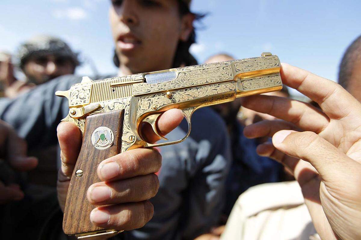 Sirte, Libyen. Wenig später ist der Langzeit-Diktator Muammar Gaddafi tot, und die Rebellen halten jubelnd seine goldene Pistole in Händen.