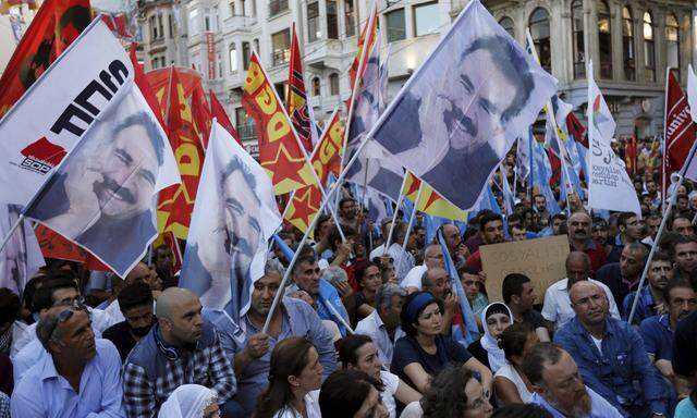 Demonstrators holding flags with the imprisonde Kurdish rebel leader Abdullah Ocalan, gather at Galatasaray square during a protests against the bomb attack in the border town of Suruc, in central Istanbul, Turkey