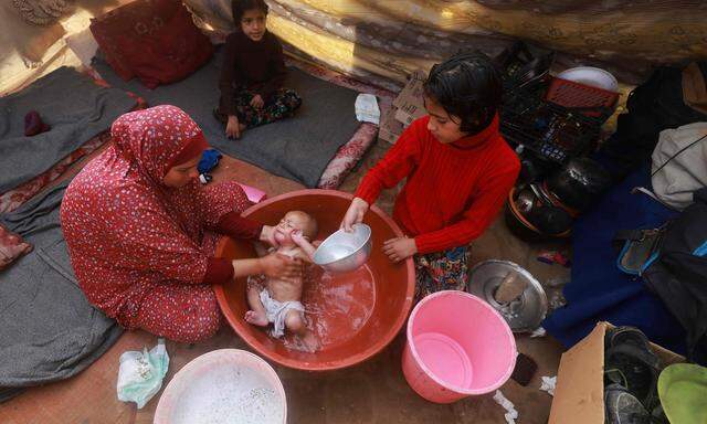 Eine Mutter badet ihr Baby in einem Flüchtlingscamp in Rafah im südlichen Gazastreifen.