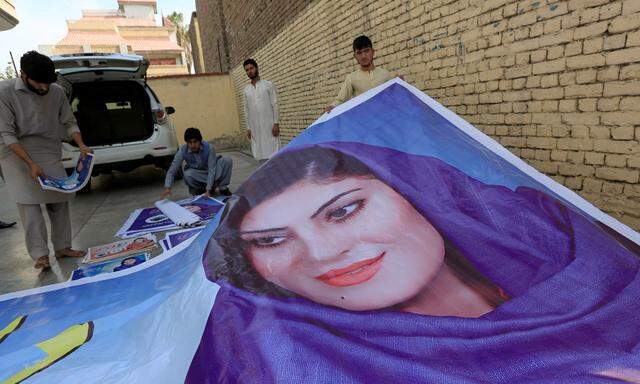 Unterstützer der Parlamentskandidatin Dewa Niazai mit einem riesigen Wahlplakat und Werbematerial in Jalalabad.