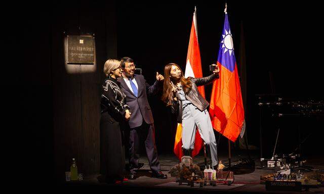 Vor Flaggen und Tafel: Debby Szu-Ya Wang, David Chienkuo Wu, Chiayo Kuo in „Dies ist keine Botschaft“ im Volkstheater.