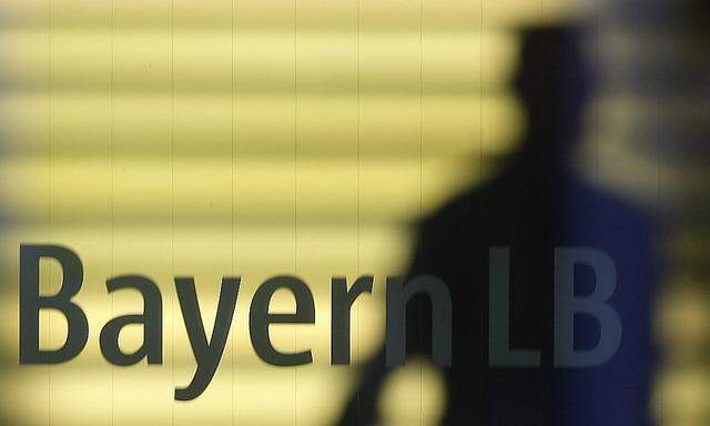 File photo of an employee of the Bavarian public sector bank BayernLB walking near the bank's logo in Munich