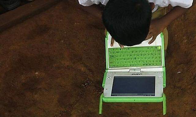 A school boy uses a laptop provided under the One Laptop Per Child project by a non-governmental or project by a non-governmental or